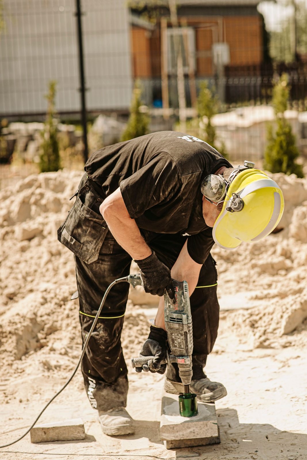 Worker operating a demolition hammer at a construction site