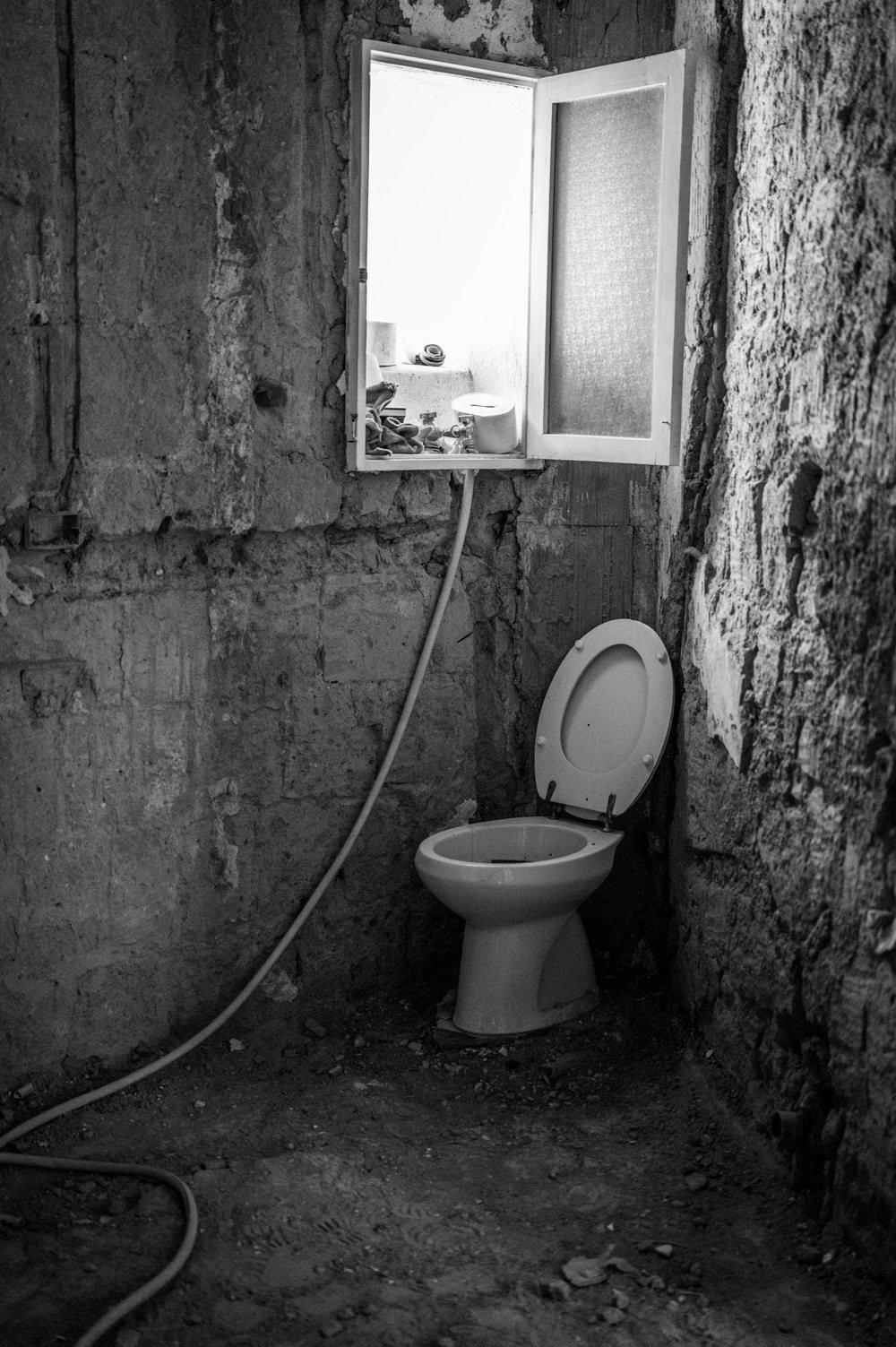 Toilet and exposed wall surfaces in an unfinished bathroom