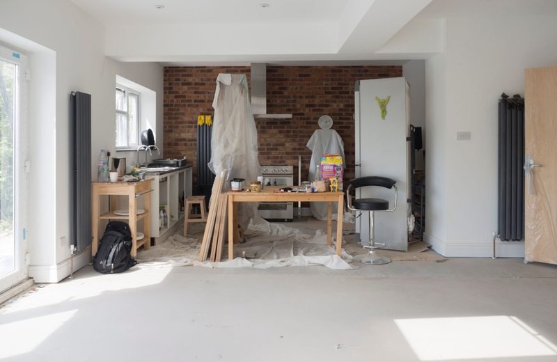 Kitchen renovation area with tools and protective sheeting
