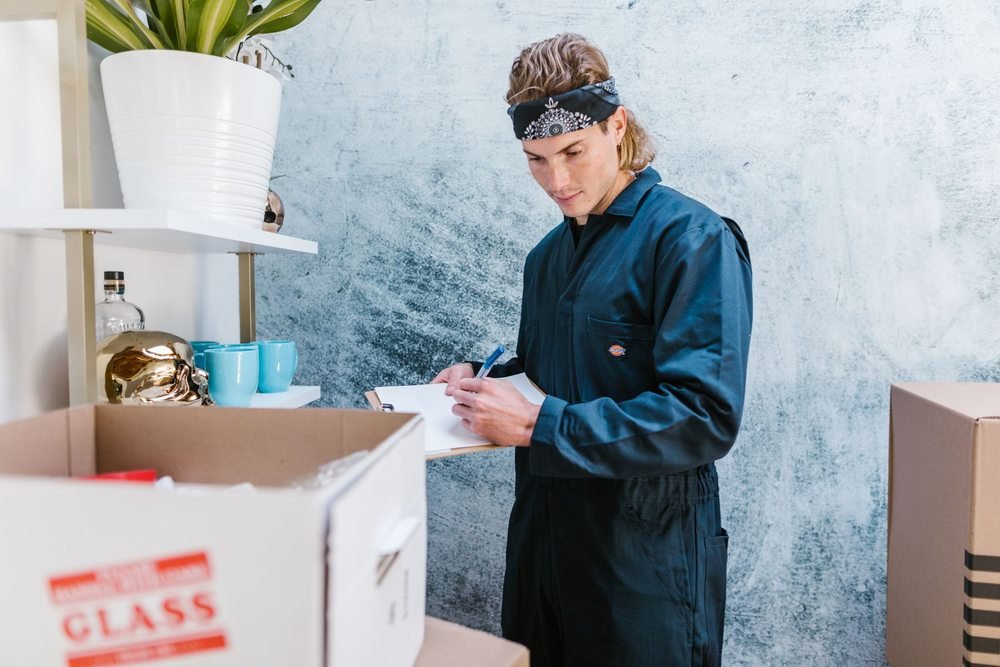 Worker reviewing household items and boxes before moving them