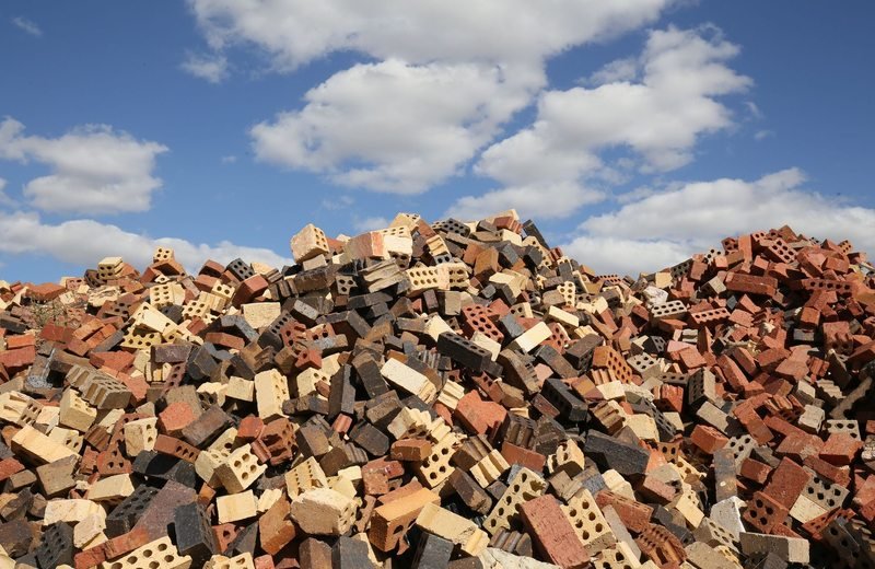 Construction bricks and blocks piled beneath a blue sky