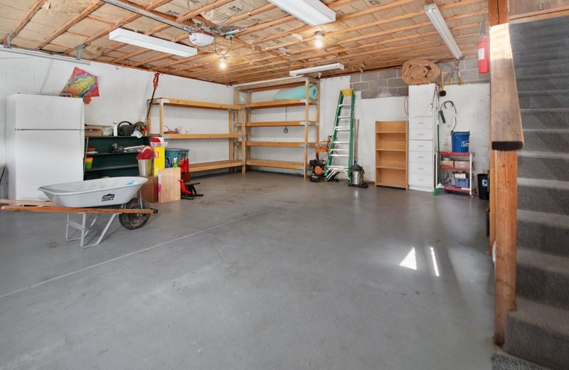 Garage interior with storage shelves and a wheelbarrow